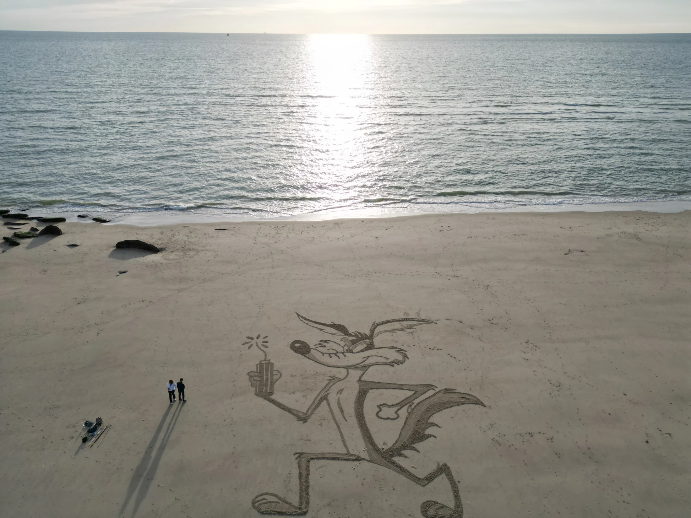 Grande fresque figurative tracée sur la plage face à la mer et à l’horizon