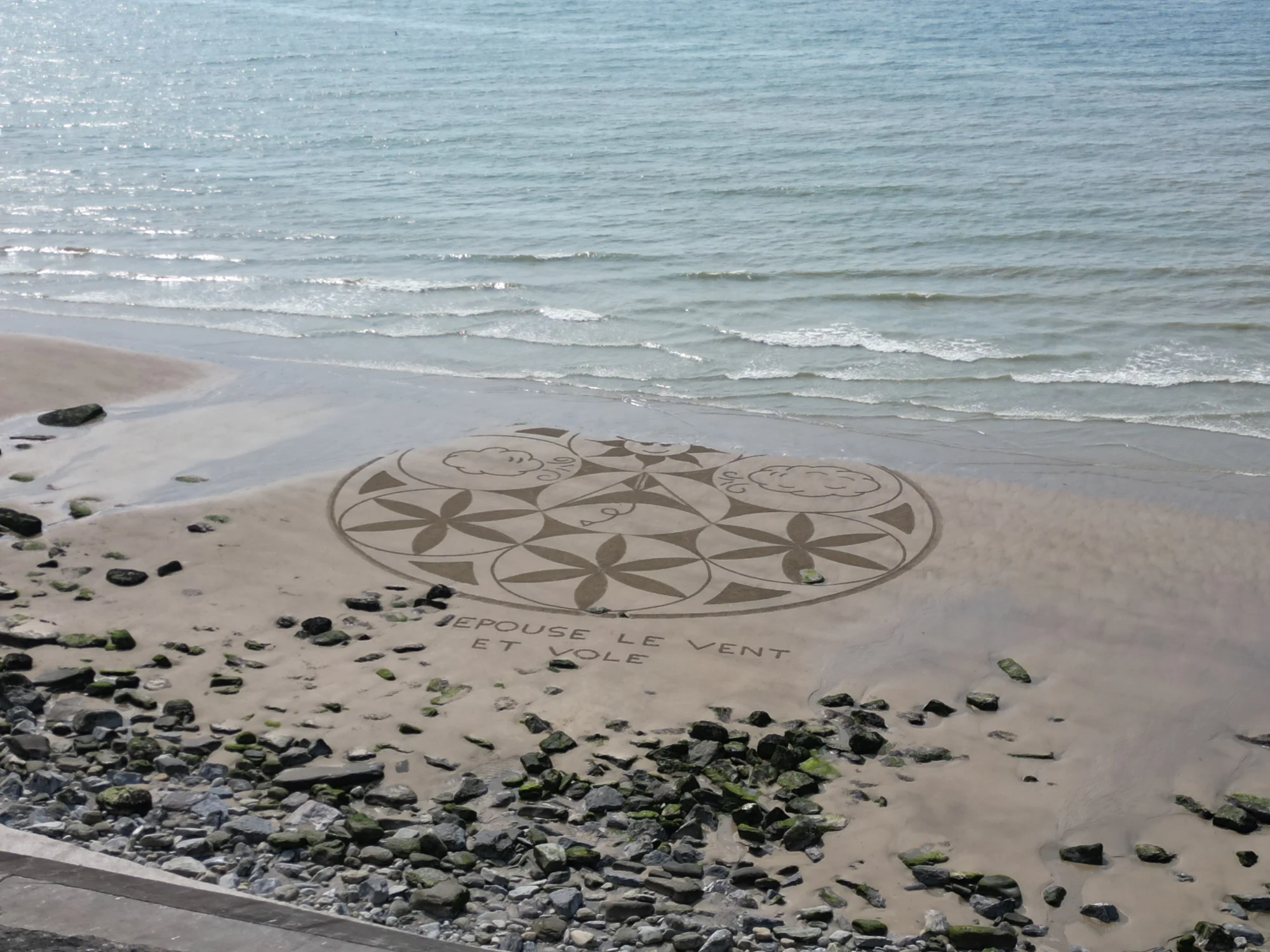 Mandala tracé dans le sable au bord de la mer avant sa transformation par la marée