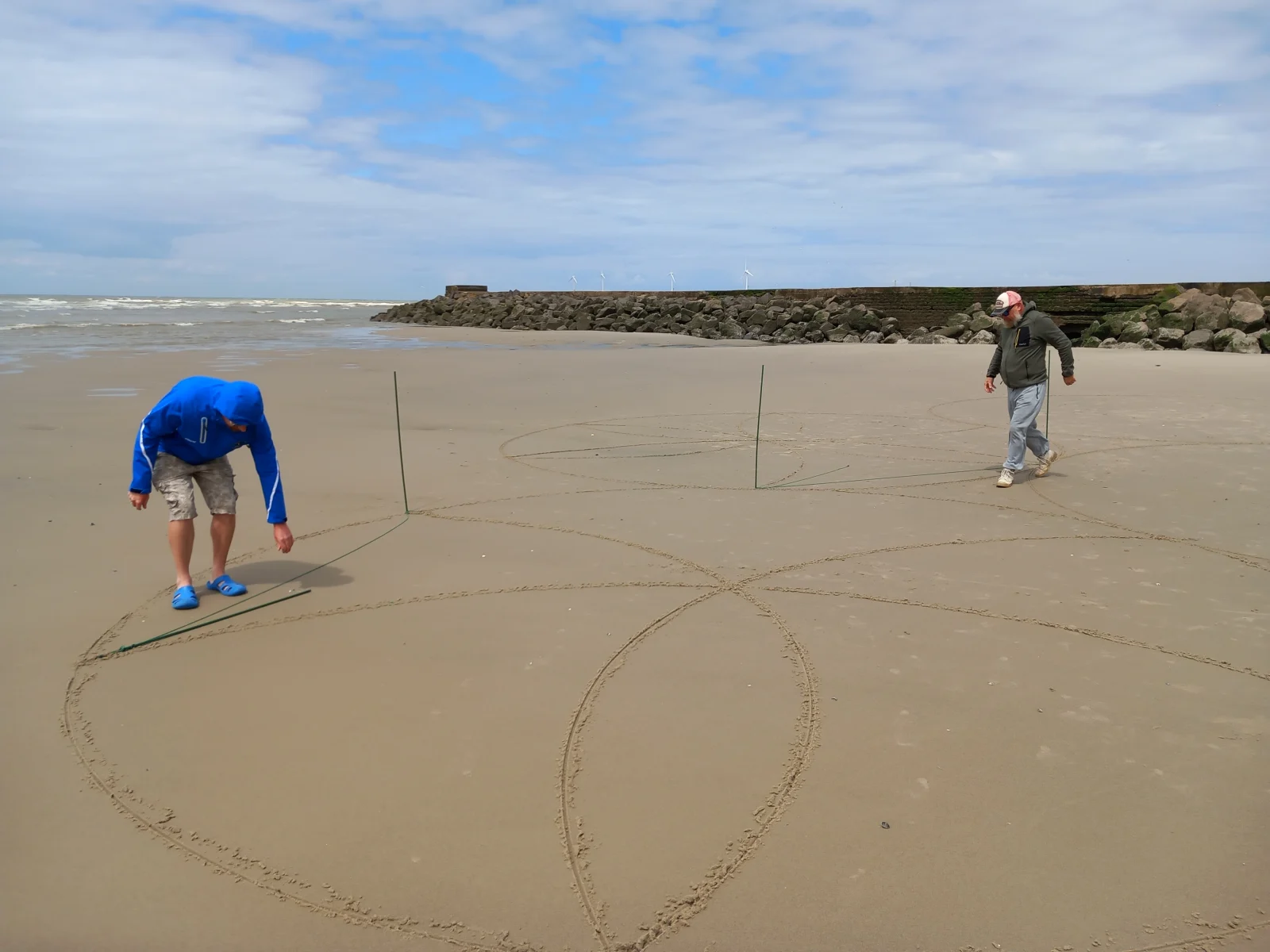 Premiers repères circulaires tracés dans le sable avant la réalisation d’un grand mandala