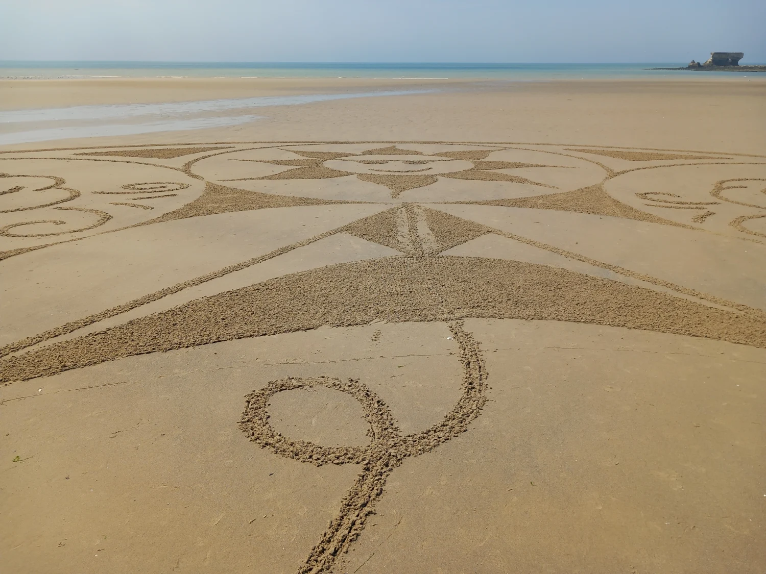 Vue au niveau du sol d’une création monumentale tracée sur la plage