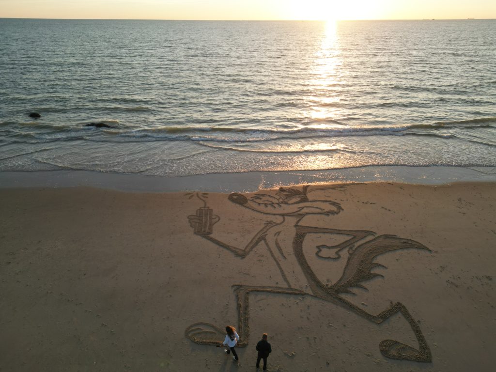 Fresque Coyote sur la plage au soleil couchant, près de la mer, avec deux personnes